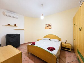 A single bed with a wooden headboard, a bedside table with a lamp, a wardrobe, a desk, and a chair. - Wonderful  villa for 5 people with A/C, WIFI, TV and patio (Marina Di Modica)