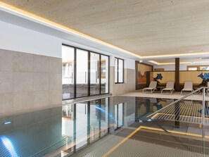 A modern hotel lobby with a glass railing, seating area, and a staircase. - Apartment in Mittersill With Swimming Pool (Mittersill)