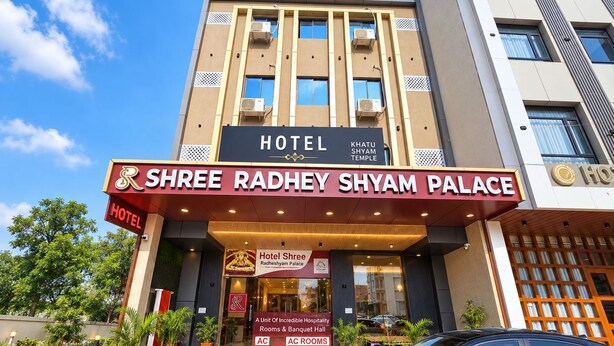 A hotel entrance with a marquee sign for Shree Radhey Shyam Palace, featuring a logo and a tagline. - Shree Radhe Shyam Palace (Khatoo)