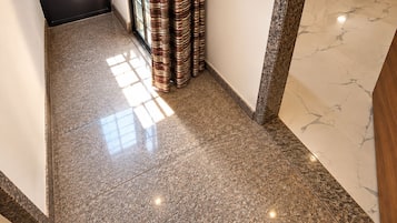 A polished stone floor leading to a doorway with a curtain.