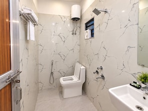 Un bagno con un WC, una doccia e un lavandino.