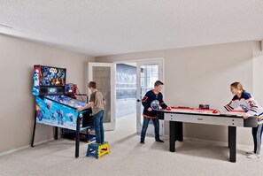 A room with a Star Wars arcade game, a table tennis table, and a hockey-themed poster. - Drop the gloves, then soak it off. A hockey house with a game room (pinball, air hockey & projector), a jacuzzi spa suite & a private backyard with deck, BBQ & fire table. 12 min to River Cree Casino, 14 min to WEM. A weekend your crew won't forget. (Edmonton)