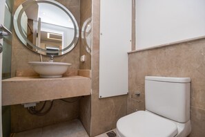 A bathroom with a round mirror, a sink, and a toilet. - Infinity Pool View Studio at Maraya El Gouna, Red Sea (Hurghada)