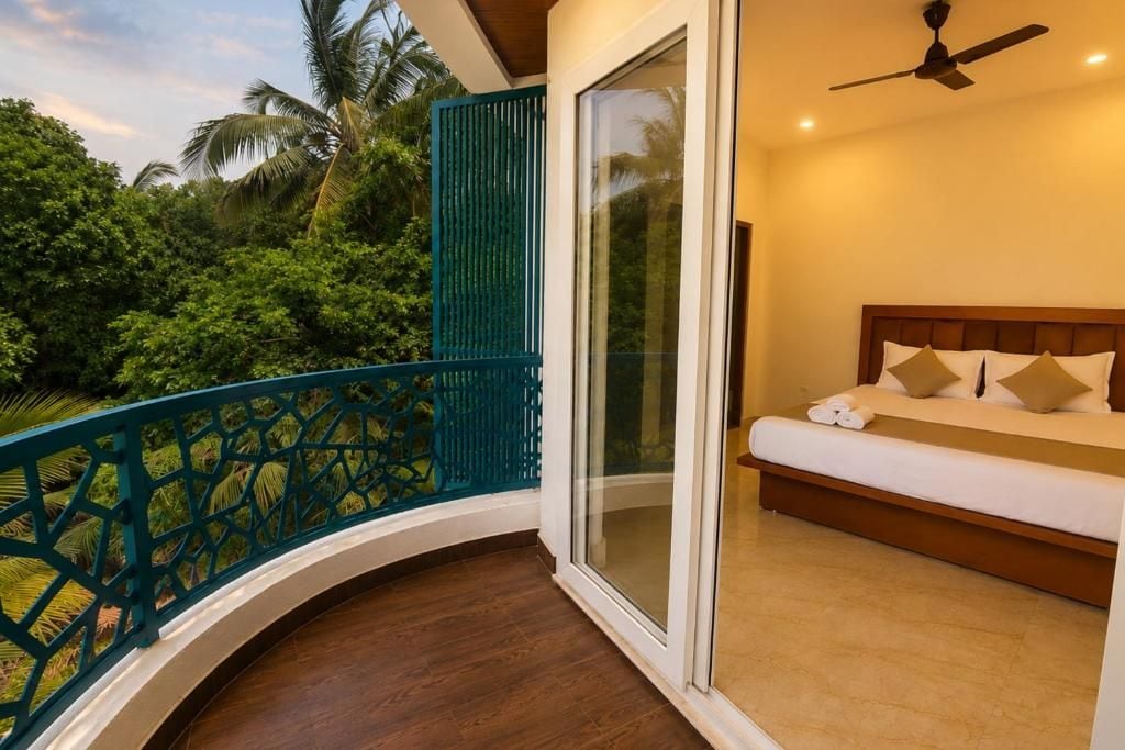 Un dormitorio con cama, ventilador de techo y vista a zonas verdes.