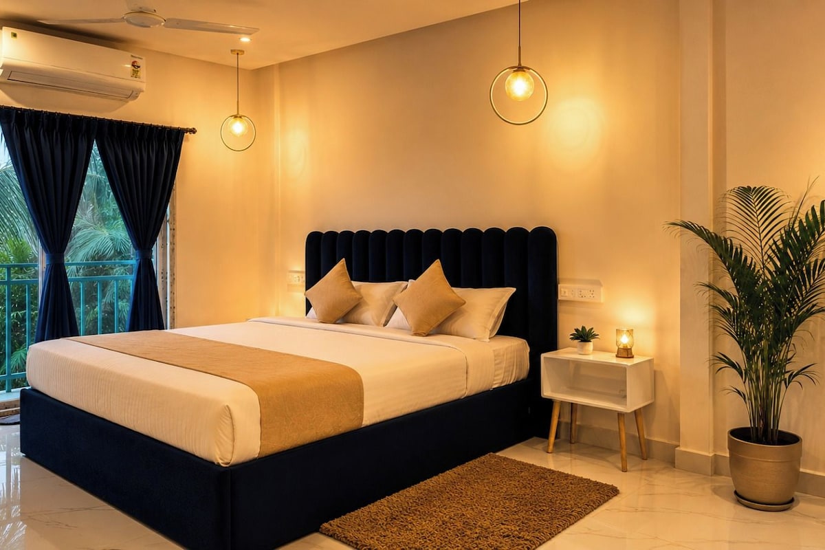 Un dormitorio moderno con una cama grande, mesitas de noche, una planta en maceta y vistas al exterior.