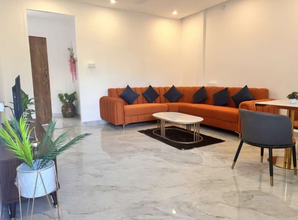 Una sala moderna con un sofá seccional, una mesa de centro y un comedor con una silla.