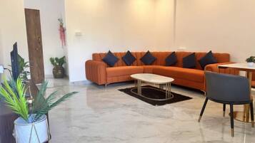 Una sala moderna con un sofá seccional, una mesa de centro y un comedor con una silla.