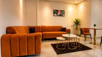A modern living room with a sectional sofa, a round coffee table, and two chairs.
