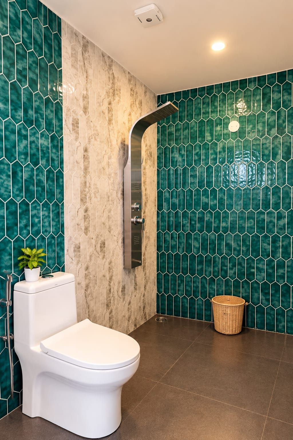 A bathroom with a toilet, a shower, and a green tiled wall.
