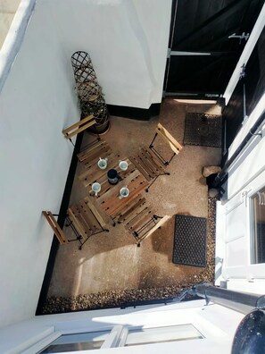 A rooftop patio with a table and chairs, a small plant, and a door. - 10 Riverside 3‑bed cosy family home sleeps 6 Nr beach (Sidmouth)