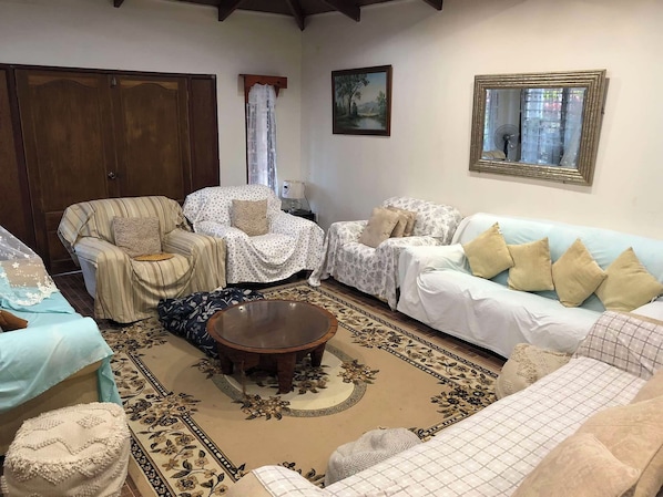 A living room with a sofa, armchairs, a coffee table, and a patterned rug.
