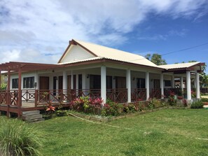 A two-story house with a covered porch, columns, and a fenced yard.