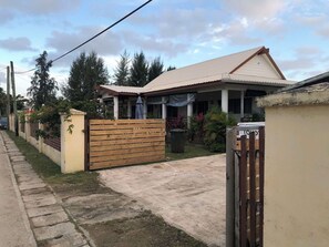 A residential property with a gated entrance, a covered porch, and a visible garage.