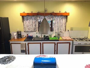 A kitchen with a stove, sink, and various appliances.