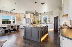 A spacious kitchen with a large island, modern appliances, and a dining area with a view.