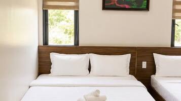 Una camera d'hotel con un letto grande, due comodini, un quadro appeso al muro e una finestra con persiane.