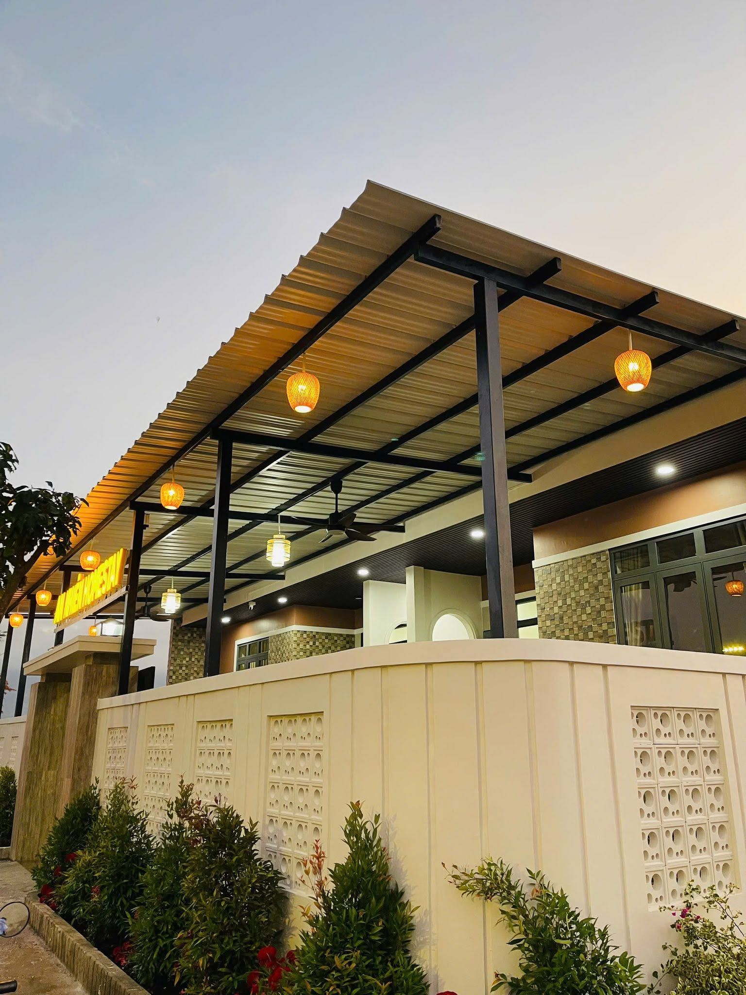A building with a covered outdoor area, featuring a flat roof and multiple hanging light fixtures.