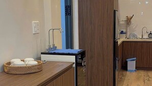 Una cocina moderna con armarios de madera, lavavajillas integrado y un lavamanos pequeño.
