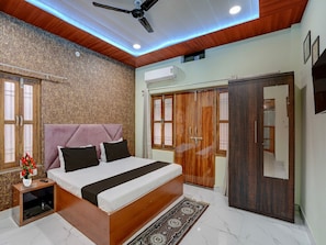 Ein Schlafzimmer mit Bett, Kleiderschrank und Deckenventilator.