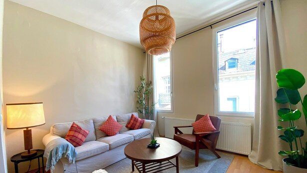 A living room with a sofa, armchair, coffee table, lamp, and a hanging light fixture. - Charming Old Town Apartment in Wiesbaden, 2 Bedrooms, Parking Garage 150 m Away (Wiesbaden)