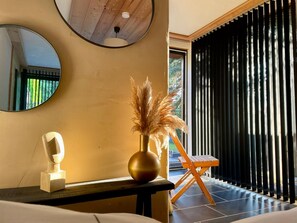 A room with a round mirror, a vase with pampas grass, a sculpture, and a wooden chair. - Naturblick Oasis - Waren (Müritz) (Waren (Müritz))