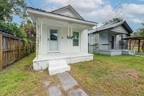 A single-story house with a front porch, a garage, and a fenced yard.