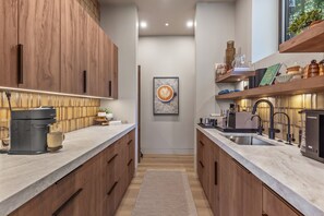 Eine moderne Küche mit Holzschränken, einer Kaffeemaschine und einem Spülbecken.