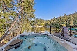 Ein Whirlpool mit Blick auf einen von Bäumen umgebenen See.