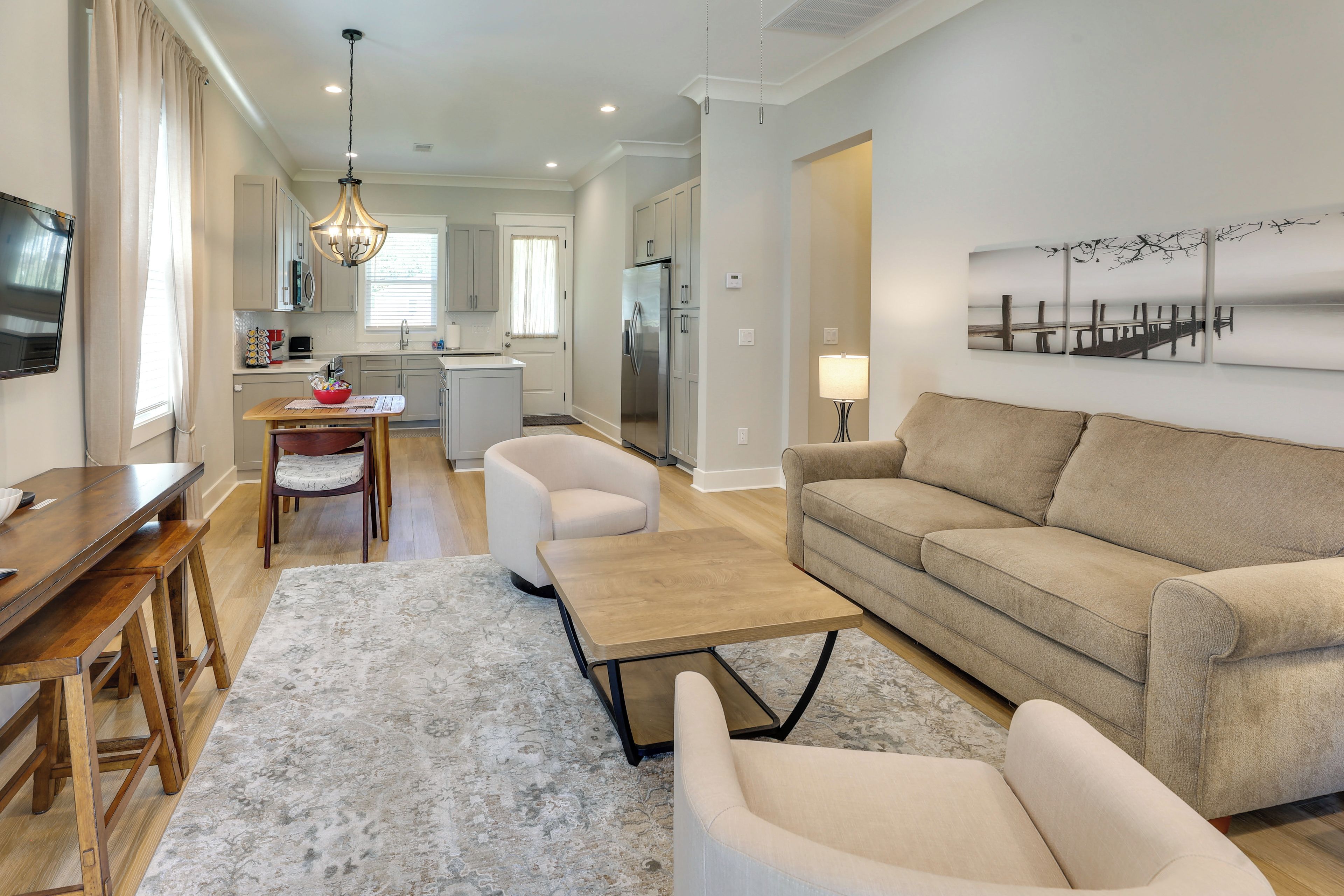A modern living room with a sofa, a coffee table, and a dining area with a table and chairs.