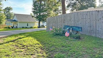 A residential area with a wooden fence, a house, and a sign that reads 'POLICE LANDING'.
