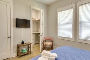 A bedroom with a bed, a television, a chair, a small table, and a closet. - Brand-new Cottage Minutes to Lake Marion & Golf (Summerton)