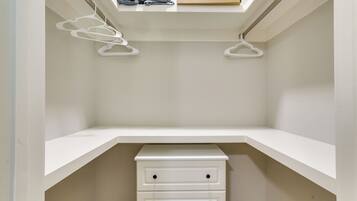 A closet with white shelving, two drawers, and a skylight above.