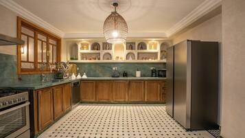 Una cocina con armarios de madera, un refrigerador de acero inoxidable y un piso con diseño.