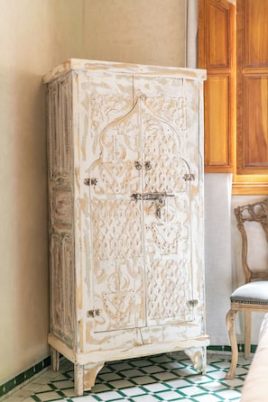 Un mueble antiguo con intrincados adornos, una puerta de madera y un cierre de metal.