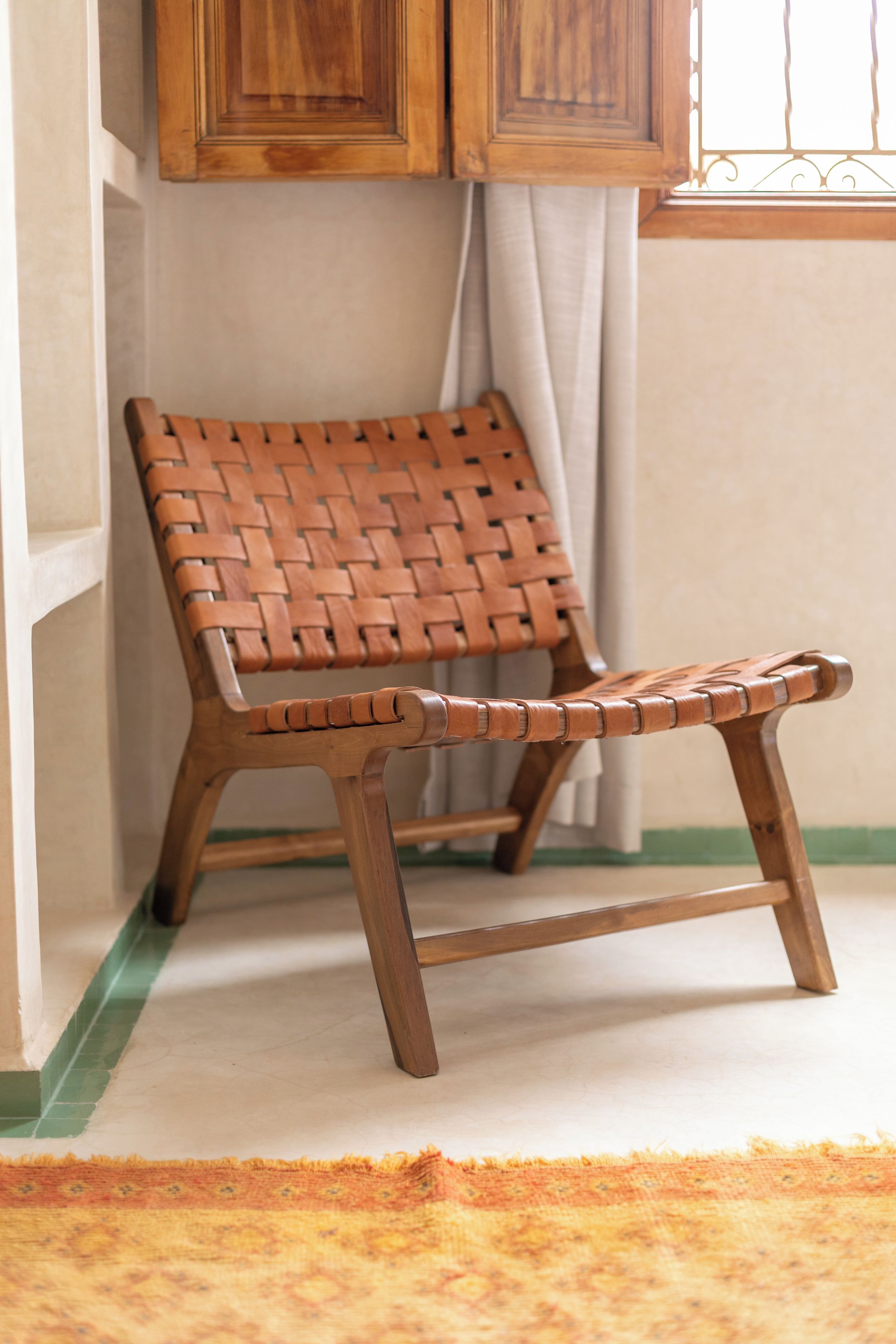 Una silla tejida con estructura de madera y asiento acolchado.