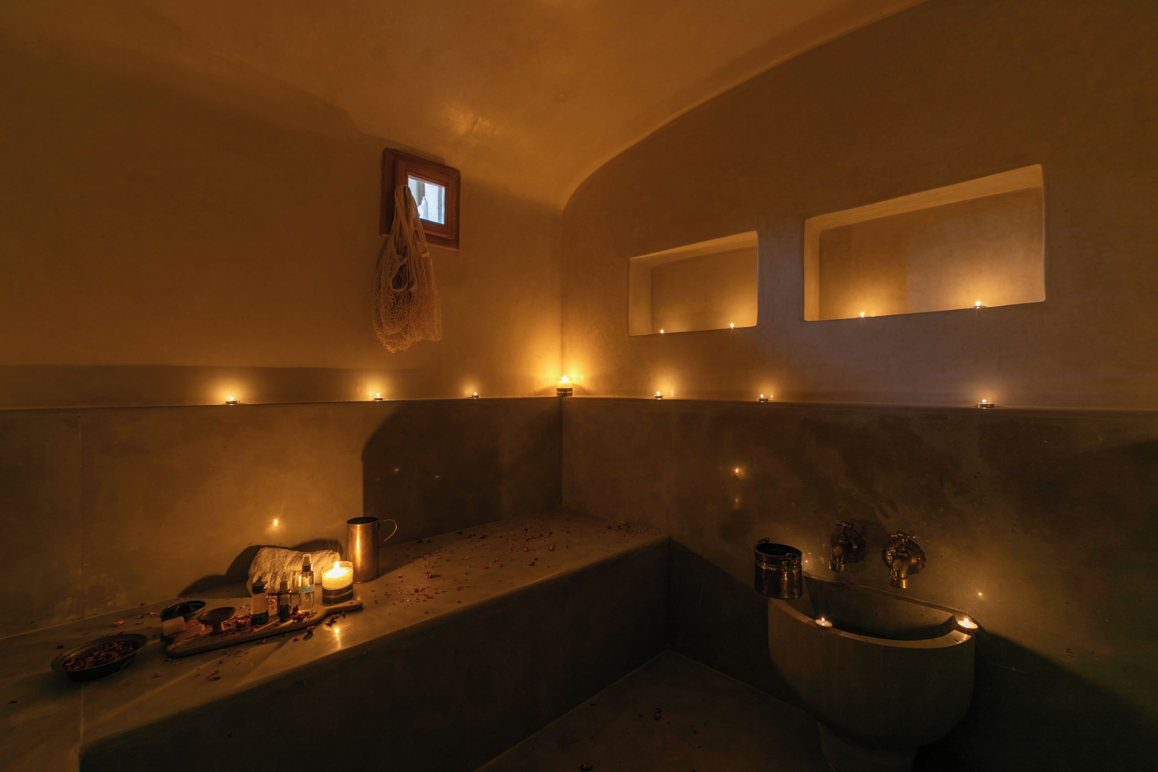 Ein schlecht beleuchtetes Badezimmer mit einer Badewanne, einem Waschbecken und einem Spiegel.