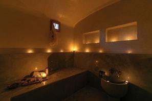 A dimly lit bathroom with a bathtub, a sink, and a mirror. - Riad Dar Razallah  (Marrakech)