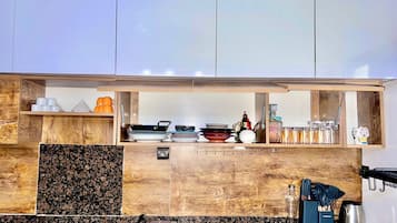 A modern kitchen with a gas stove, wooden cabinets, and a granite countertop.