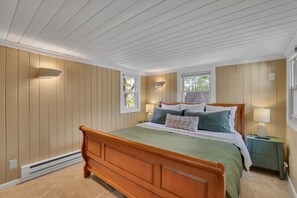 A bedroom with a wooden bed, two bedside tables, and a window. - Serenity Retreat | Hot Tub + Fire Pit | Walk Downtown (West Hartford)
