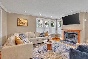 A living room with a sofa, a coffee table, and a fireplace.