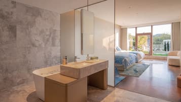A modern bathroom with a large mirror, a bathtub, and a vanity with a sink.