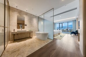 Ein modernes Badezimmer mit einer freistehenden Badewanne, einem großen Spiegel und einem Waschtisch.