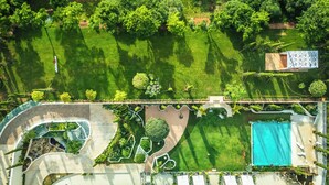 An aerial view of a landscaped property with a swimming pool, garden areas, and a covered outdoor seating area. - SKANDURA GARDEN HOTEL DIANCHI (Kunming)