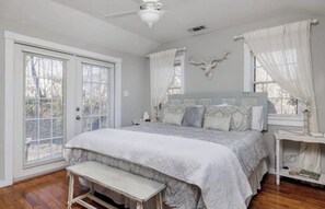 Ein Schlafzimmer mit einem großen Bett, einer Bank, einem Deckenventilator und einer Wanddekoration mit einem Hirschkopf.