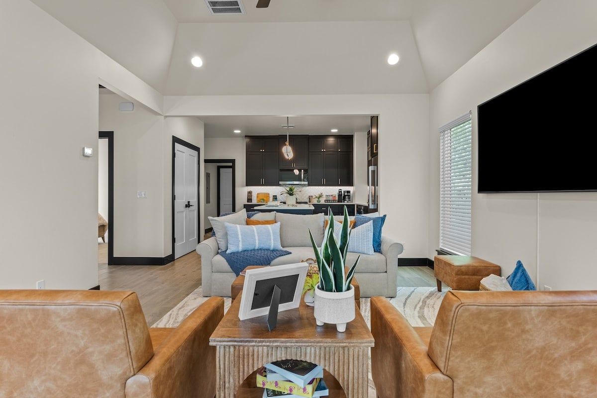 A modern living room with a sofa, coffee table, and a flat-screen TV.