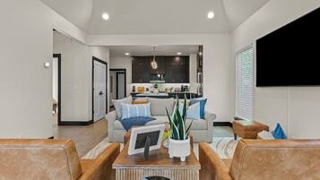 A modern living room with a sofa, coffee table, and a flat-screen TV.