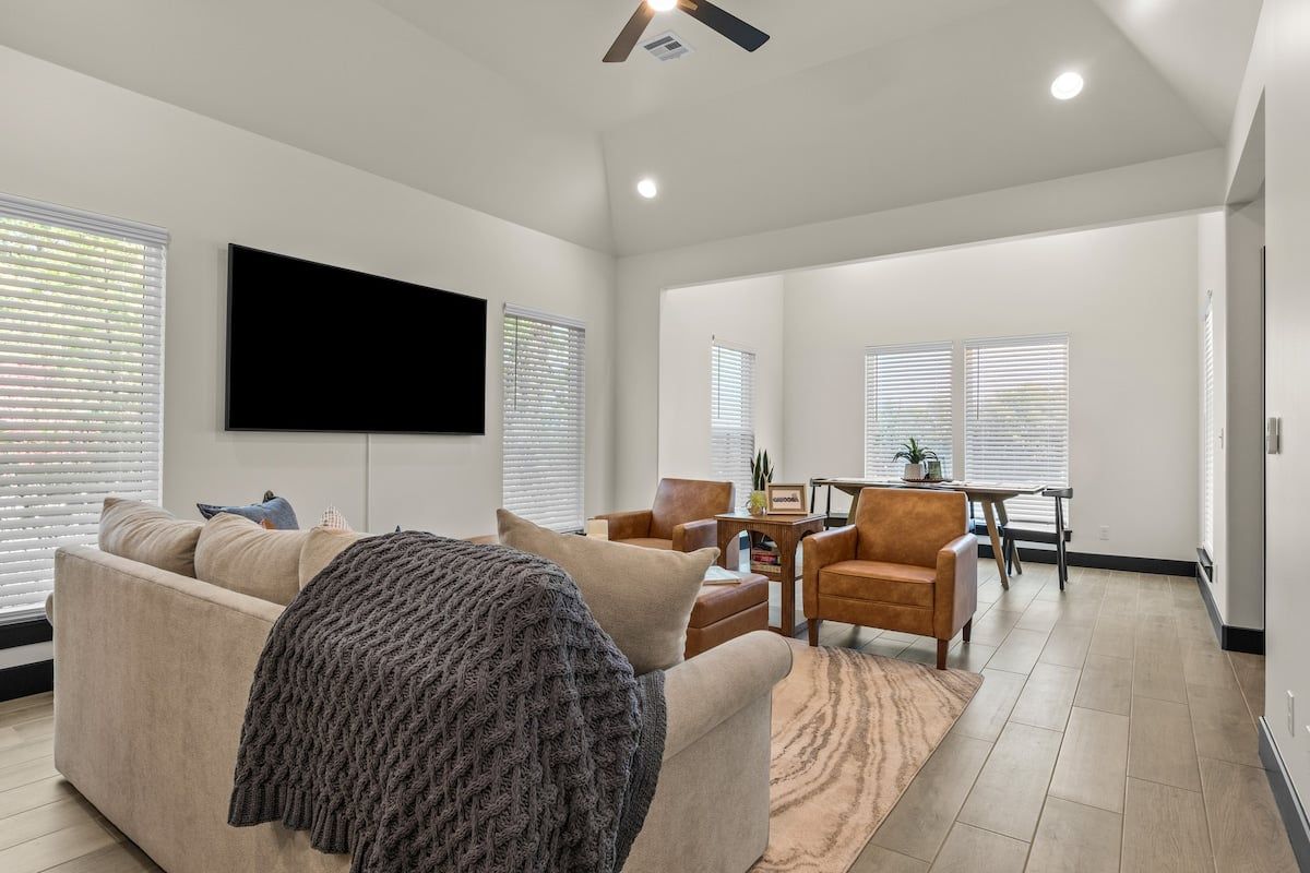 A modern living room with a flat-screen TV, a sofa, and a coffee table.