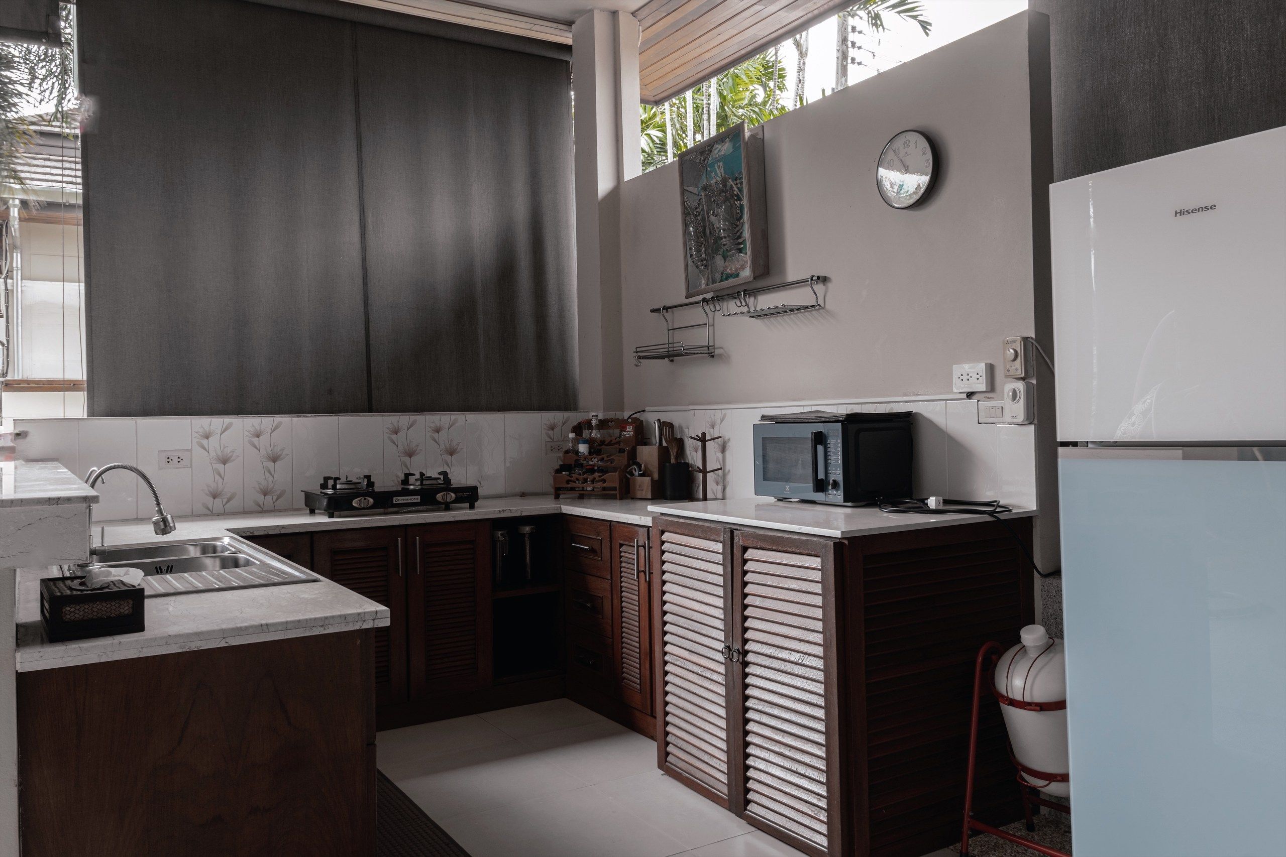 Une cuisine moderne équipée d’une cuisinière à gaz, d’un four à micro-ondes et d’un réfrigérateur.
