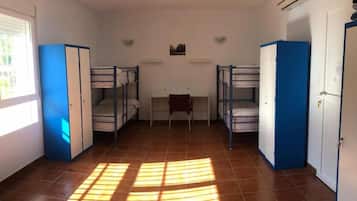 Un dormitorio con literas, un escritorio y una ventana.