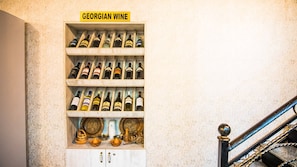 A wooden wine rack labeled 'GEORGIAN WINE' with multiple bottles. - Old Georgia (Tbilisi)